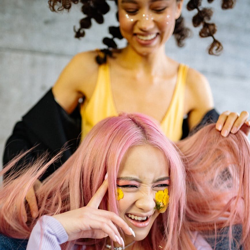 a woman playing with her friend s hair