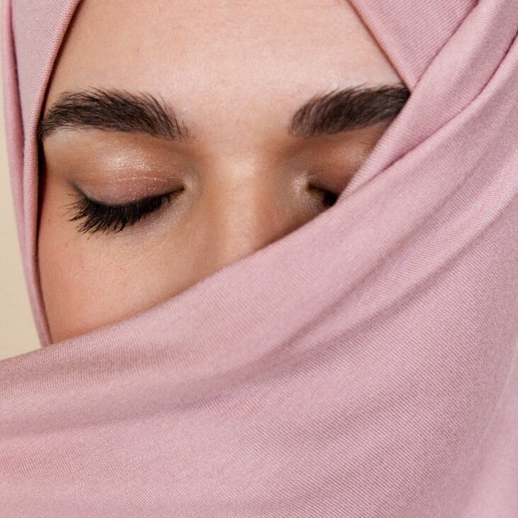 a woman in pink hijab with her eyes closed
