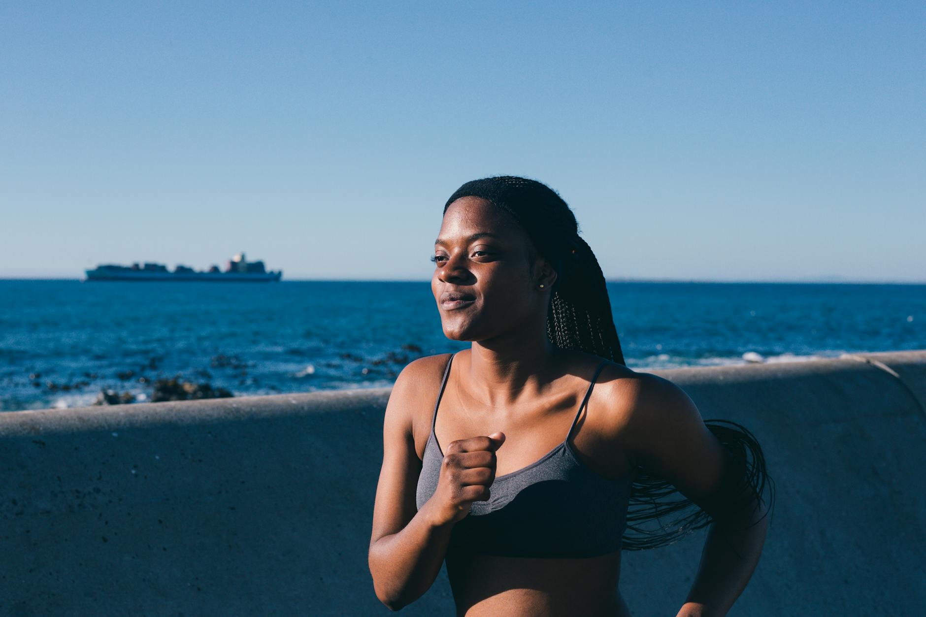 woman in active wear jogging by the bay